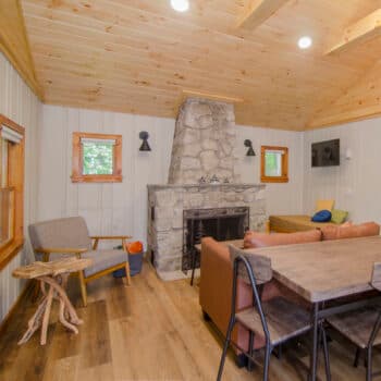 Renovated cottage interior with stone fireplace and pine ceiling